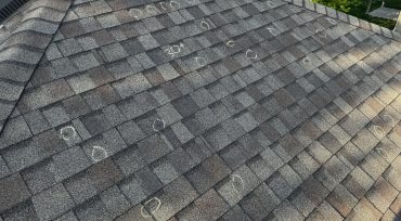 Hail hits on Asphalt shingle Chalk-circled hail bruise on asphalt shingle