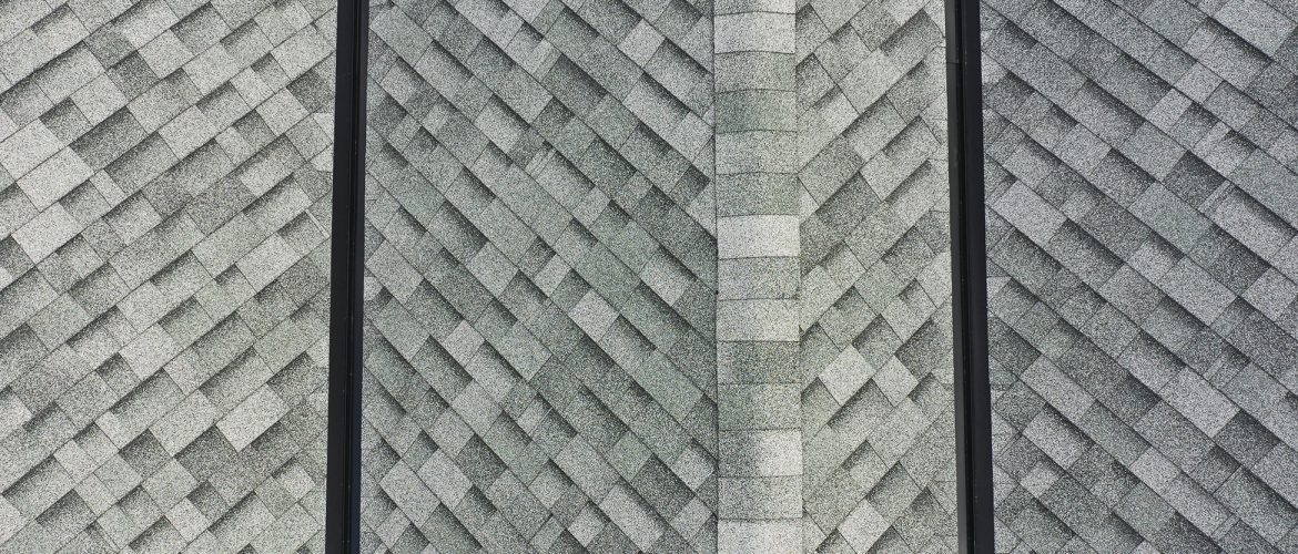 Close up of two freshly installed black valley metals on a roof