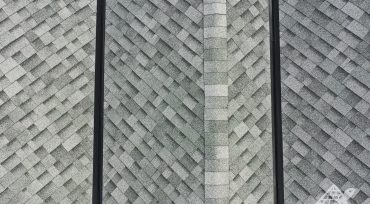 Close up of two freshly installed black valley metals on a roof