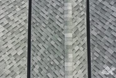 Close up of two freshly installed black valley metals on a roof