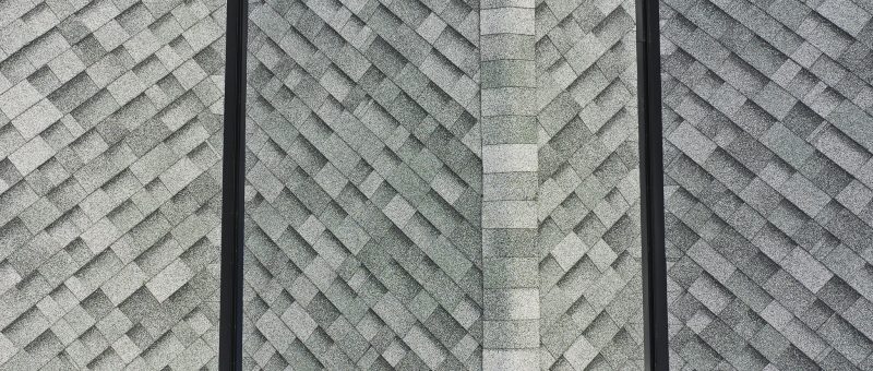 Close up of two freshly installed black valley metals on a roof